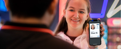 Girl buying cinema tickets and showing her status as an over 15 with her Yoti ID