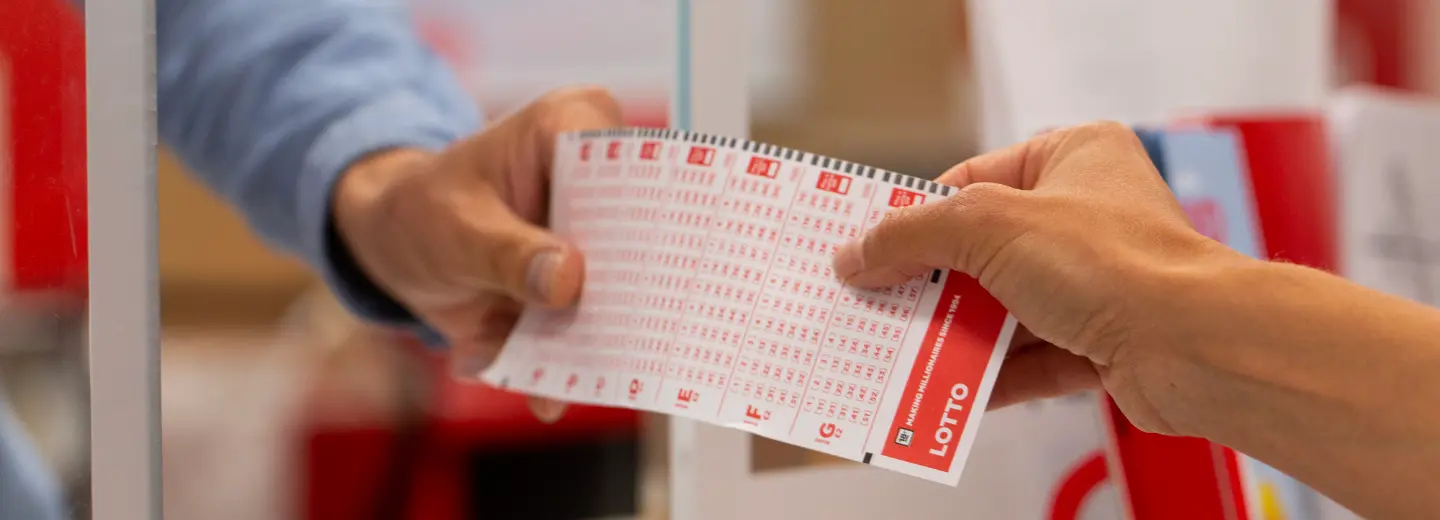 Someone receiving a lottery slip from a cashier