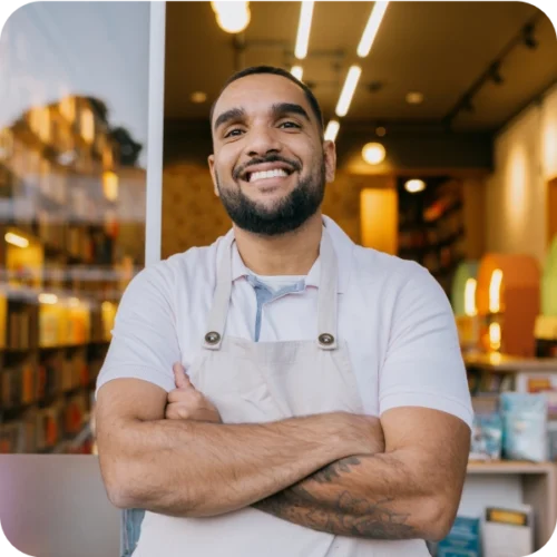 Man wearing apron stood in front of shop