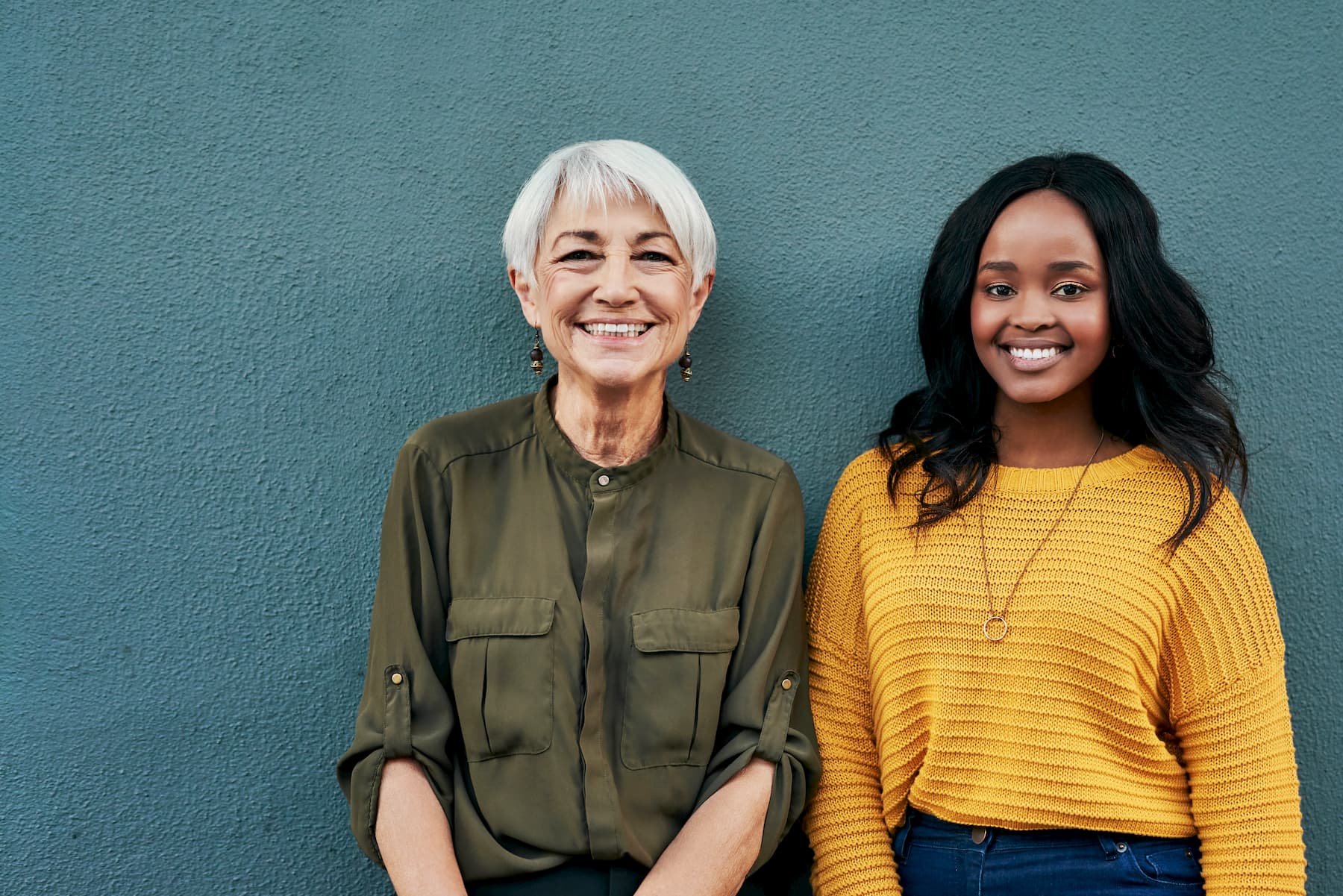 Two women stood against a wall together