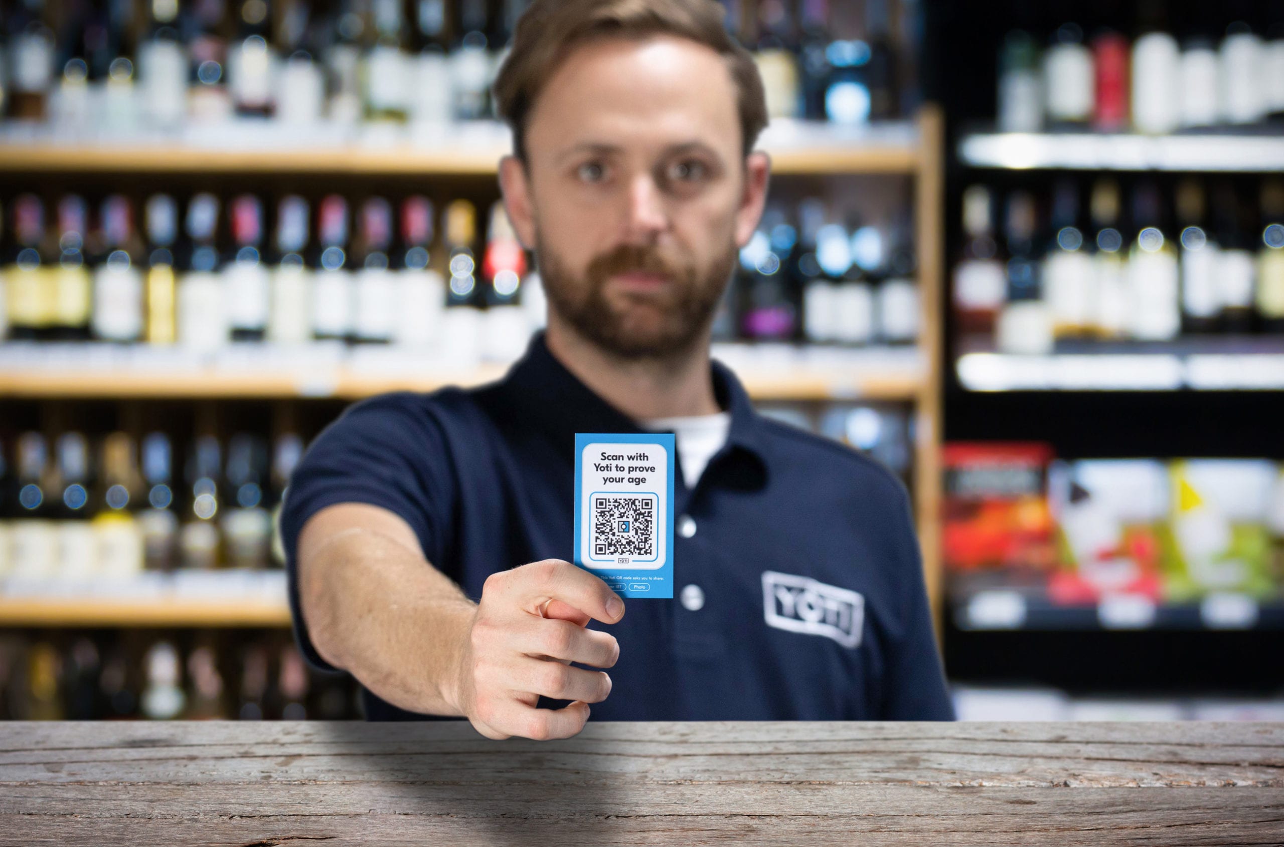 Man holding yoti QR card up to customer