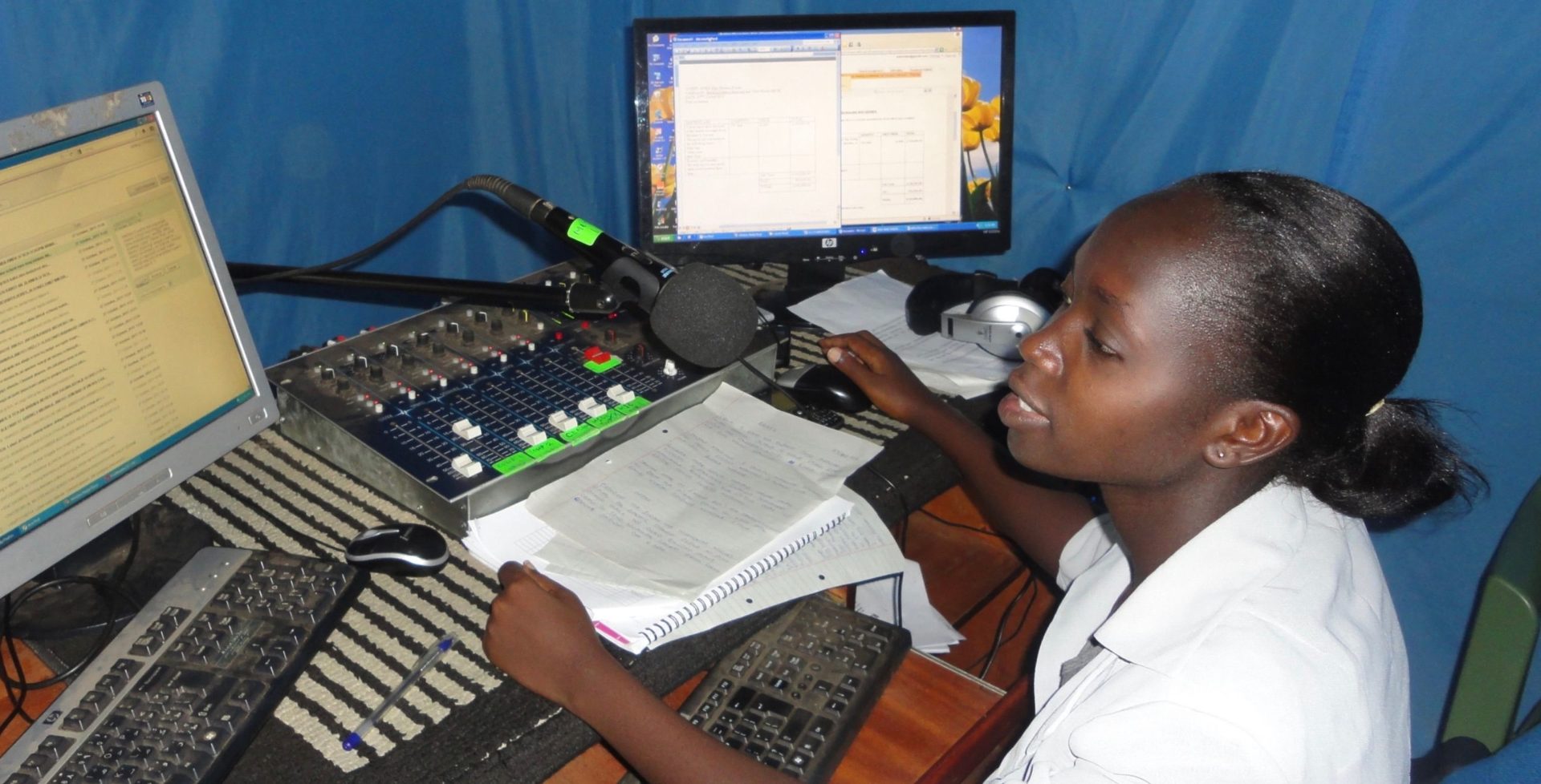 an image of a young girl in front of a computer. she is creating a podcast