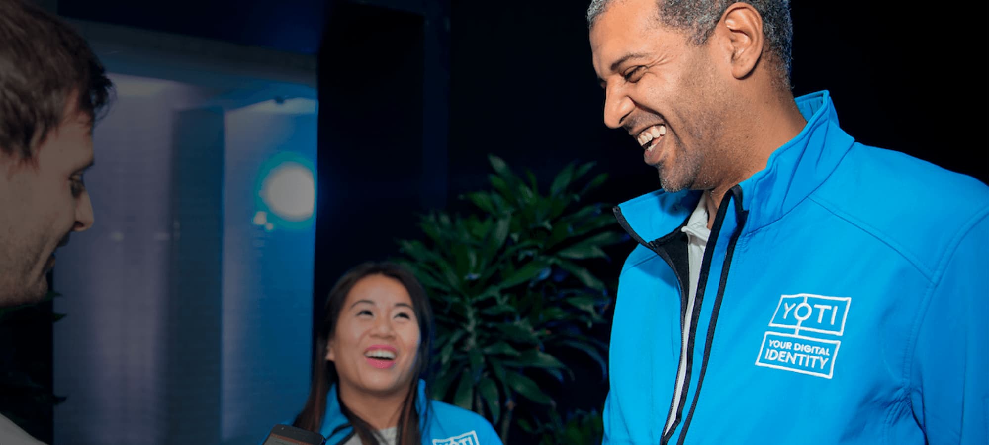 We want to hear about your charity’s digital identity needs an image of three Yoti colleagues who are laughing amongst themselves