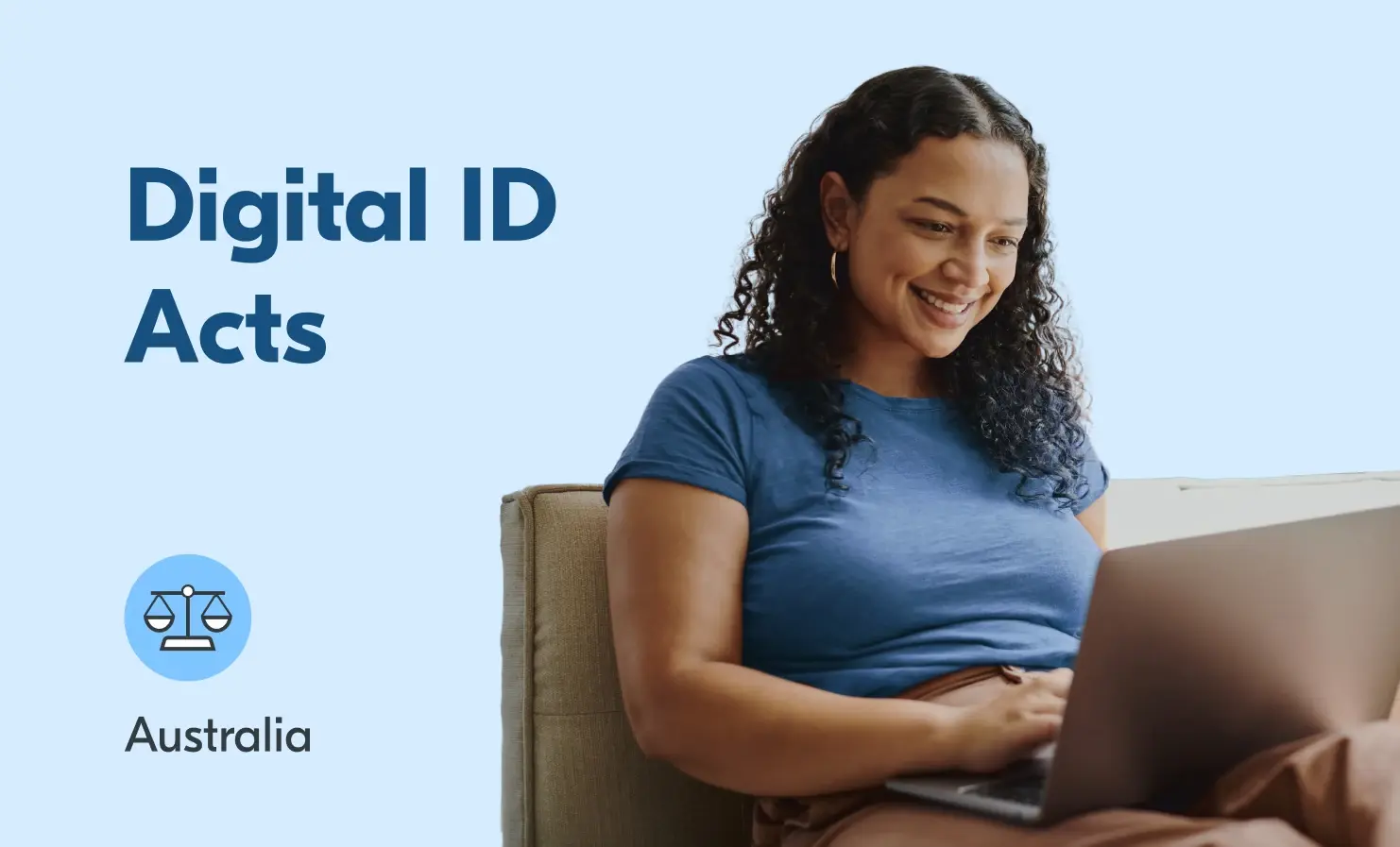 A woman smiling whilst sitting down and using a laptop.