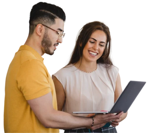 Two people smiling while looking at a laptop