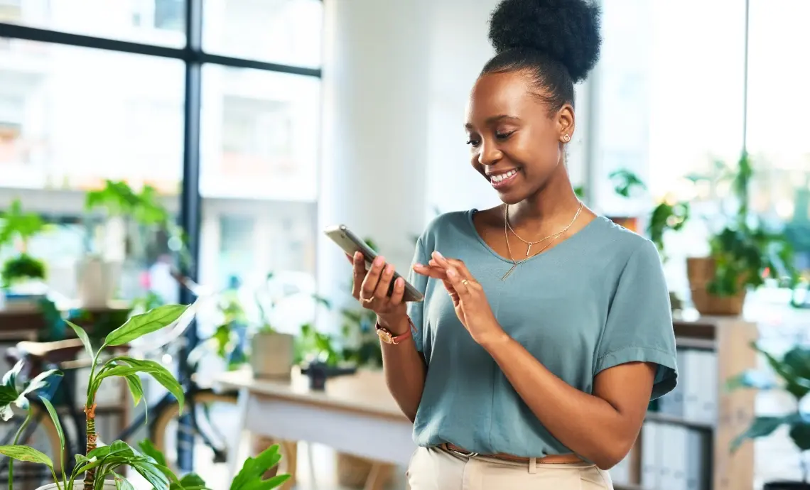 Woman surrounded by green plants using her smartphone