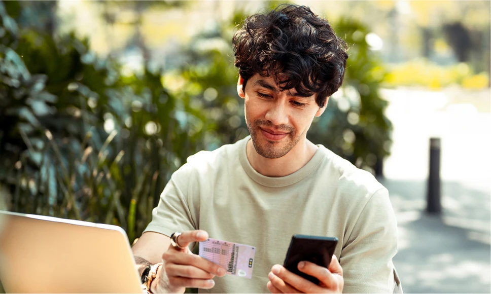 Young man adding his Identity details from a driving licence to his smartphone