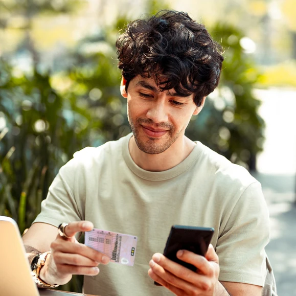 Young man adding his Identity details from a driving licence to his smartphone