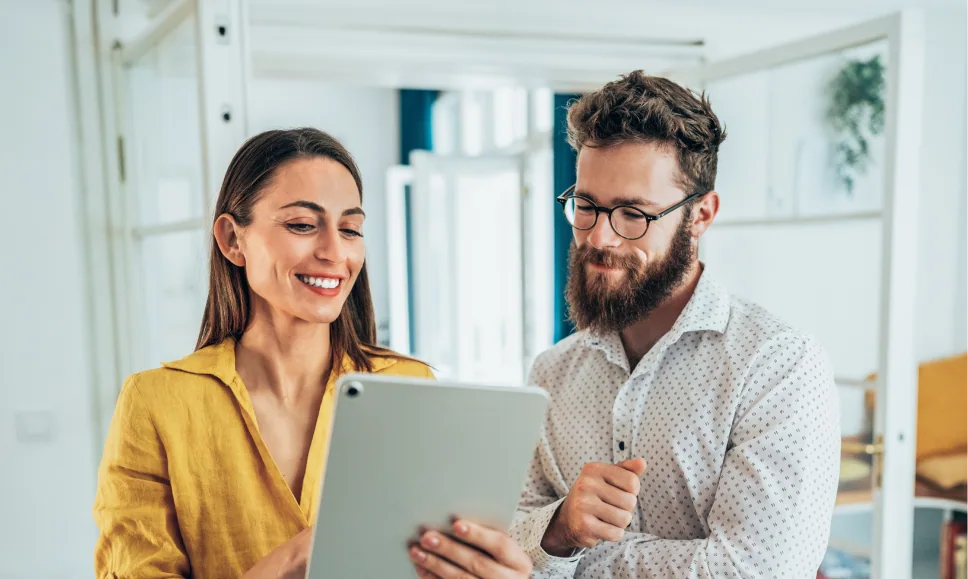 Woman showing something to a man on her tablet