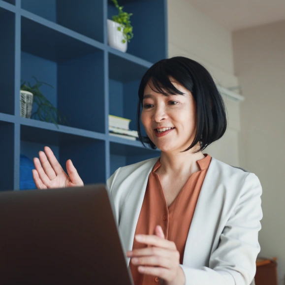 Woman in business attire in an online meeting on a laptop