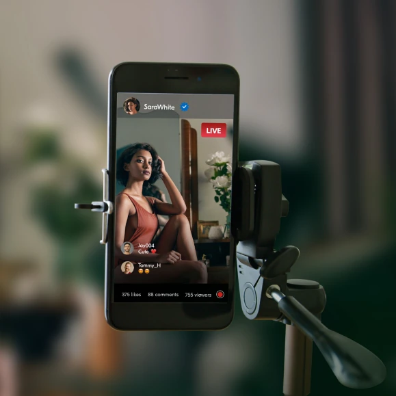 Woman filming an adult scene with her smartphone on a tripod