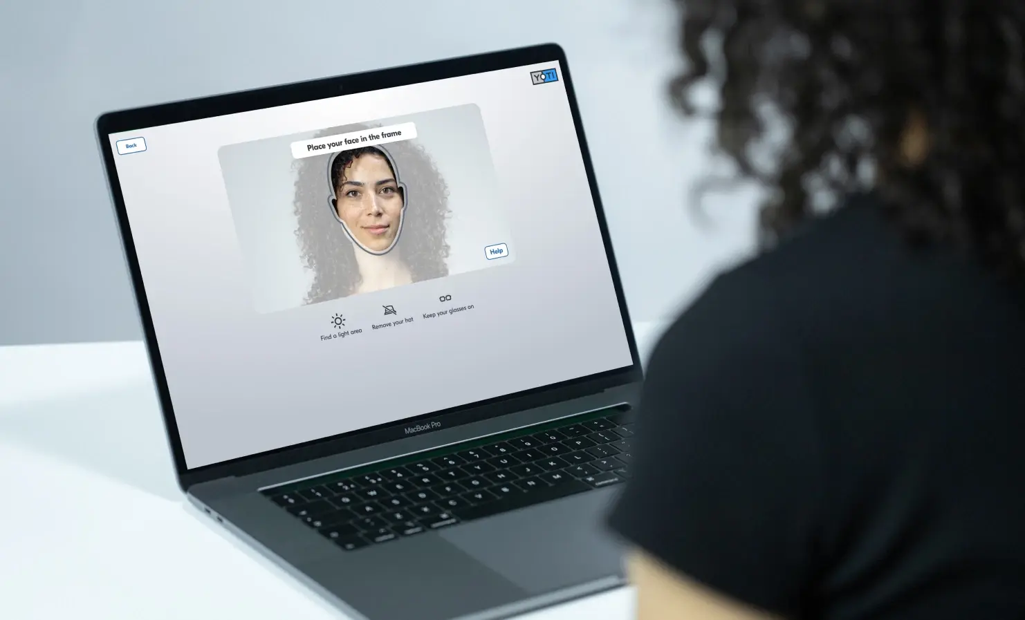 A person using Yoti's facial age estimation technology on a laptop.