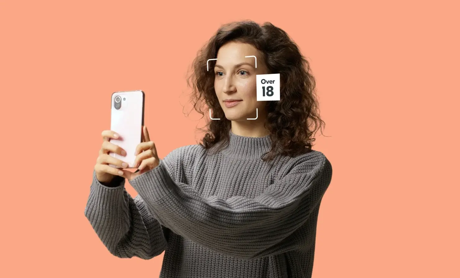 An image of a person holding their phone up and performing a facial age estimation.